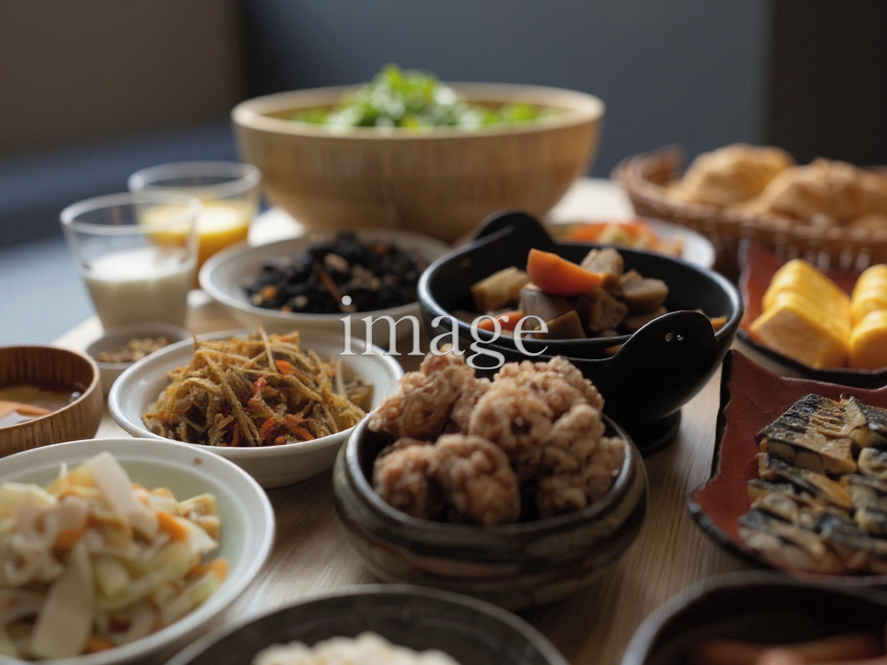 Variedad de platos, incluyendo un tazón grande de sopa, varios tazones pequeños con diferentes alimentos y un plato con pan.