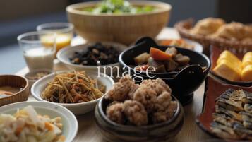Variedad de platos, incluyendo un tazón grande de sopa, varios tazones pequeños con diferentes alimentos y un plato con pan.