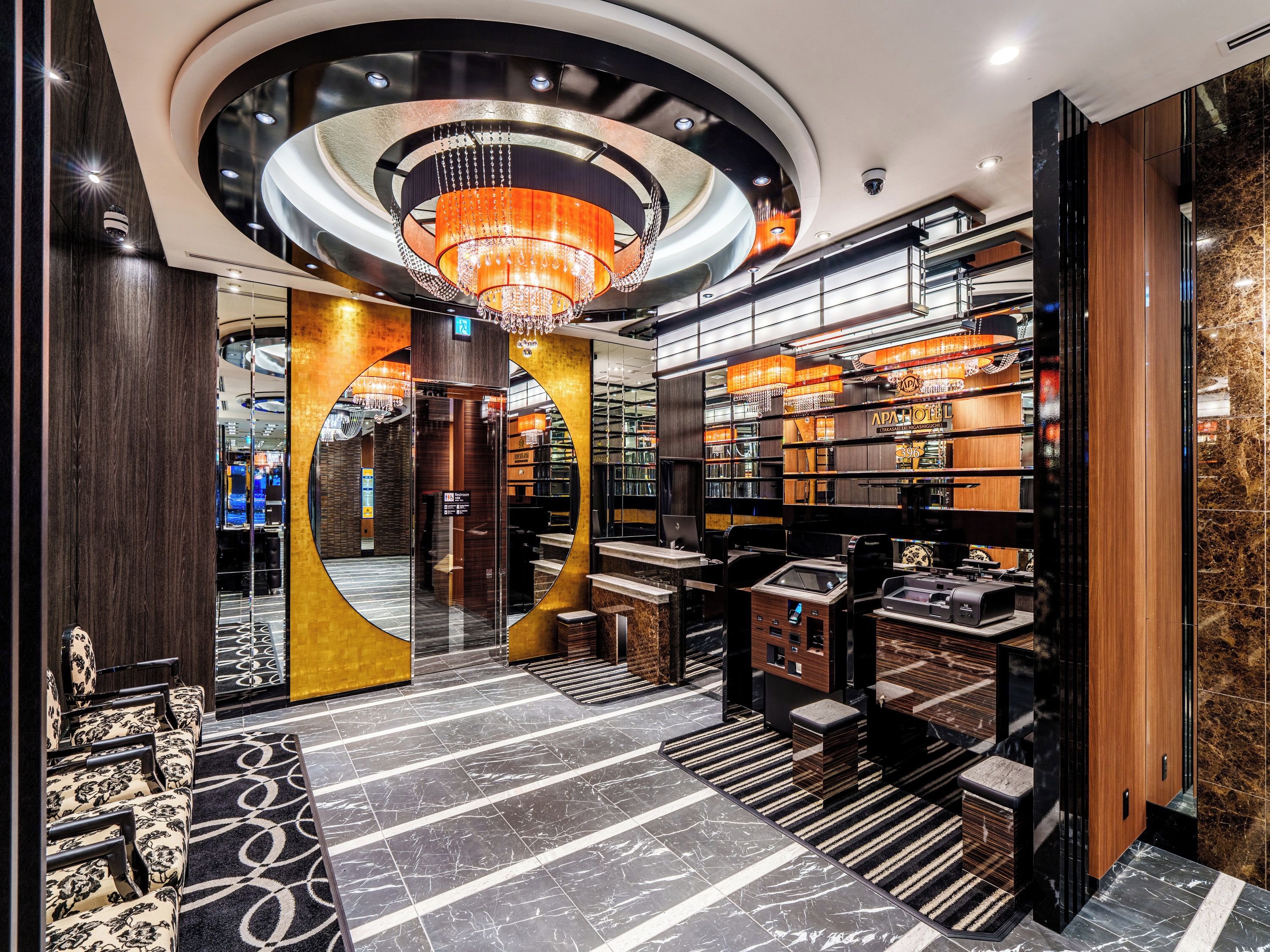 A hotel lobby with a grand chandelier, marble flooring, and a modern design.