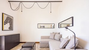 A modern living room with a sofa, coffee table, and a cabinet. - Stairway to the Vista Flat (Naples)