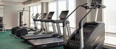A gym with treadmills, ellipticals, and a stationary bike.