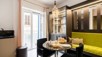 Un salon moderne comprenant une table à manger, un canapé et une bibliothèque intégrée.