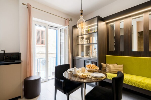 Una sala de estar moderna con una mesa de comedor, un sofá y una estantería empotrada.