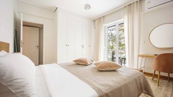 Een slaapkamer met een bed, een bureau, een stoel en uitzicht op de omgeving.