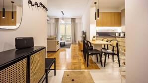 A modern apartment with a living area, dining space, and kitchen. - Attica Skyline Living (Athens)