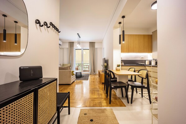 A modern apartment with a living area, dining space, and kitchen. - Attica Skyline Living (Athens)
