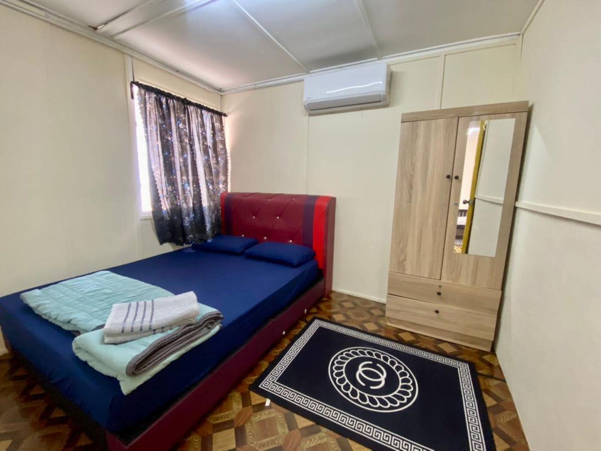 Un dormitorio con cama, armario y aire acondicionado.