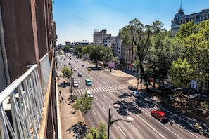 A city street with buildings, trees, and vehicles.