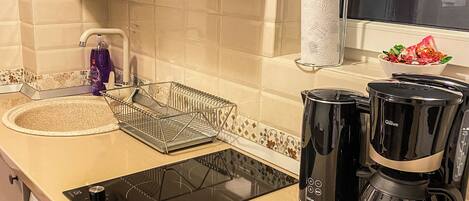 Une cuisine équipée d’un lave-linge, d’une machine à café et d’un égouttoir à vaisselle.