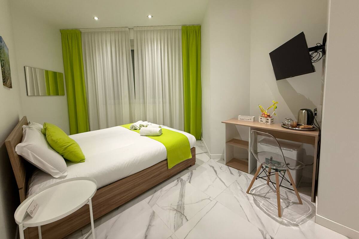 Una habitación de hotel moderna con una cama, un escritorio y una silla.