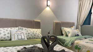 Ein Hotelzimmer mit zwei Betten, jeweils mit blumigem Bettbezug und passenden Kissen. Über den Betten befindet sich eine Wandleuchte, und ein kleiner Tisch mit einer Vase und dekorativen Ästen.