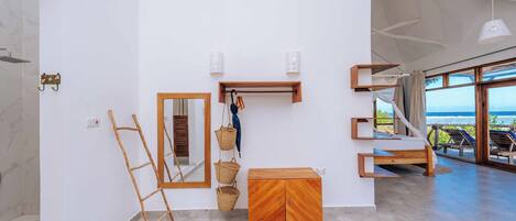 Une chambre moderne avec une grande fenêtre, un meuble en bois, un miroir et une échelle.