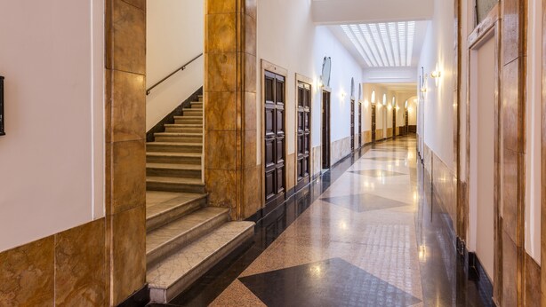 A hotel lobby with a marble staircase, a sign reading "SCALA", and a long corridor with doors and lighting fixtures. - 504 Corso Suites (Rome)