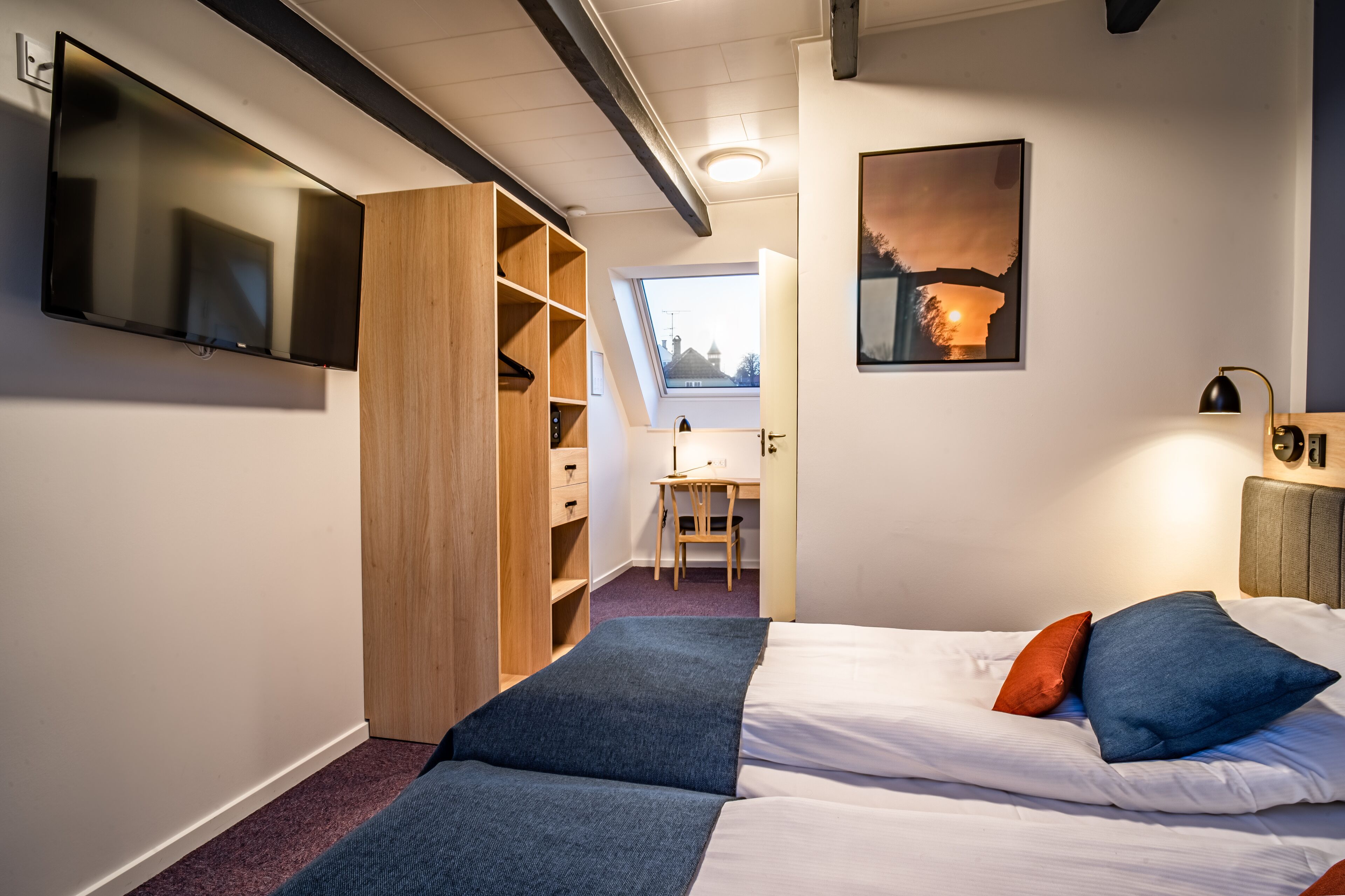 Un dormitorio con cama, escritorio y armario.
