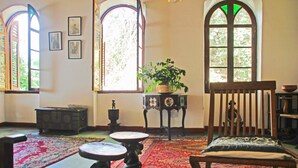 A room with a wooden chair, a table, a potted plant, and a rug. - Hiliki House (Zanzibar Town)