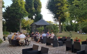 An outdoor patio with wicker furniture and a small gazebo. - Villa Primerose (Arcis-sur-Aube)