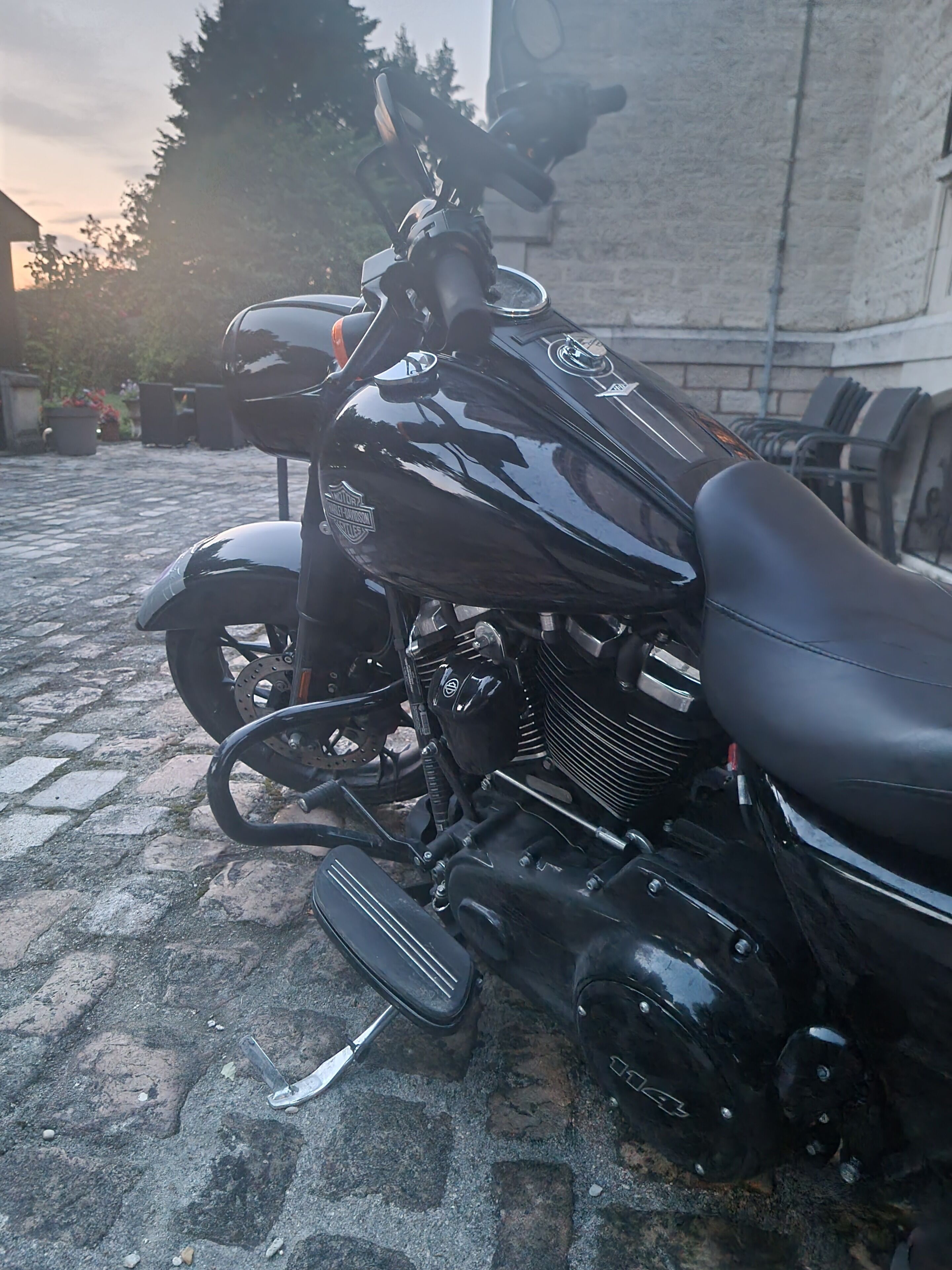 A motorcycle parked on a cobblestone surface.