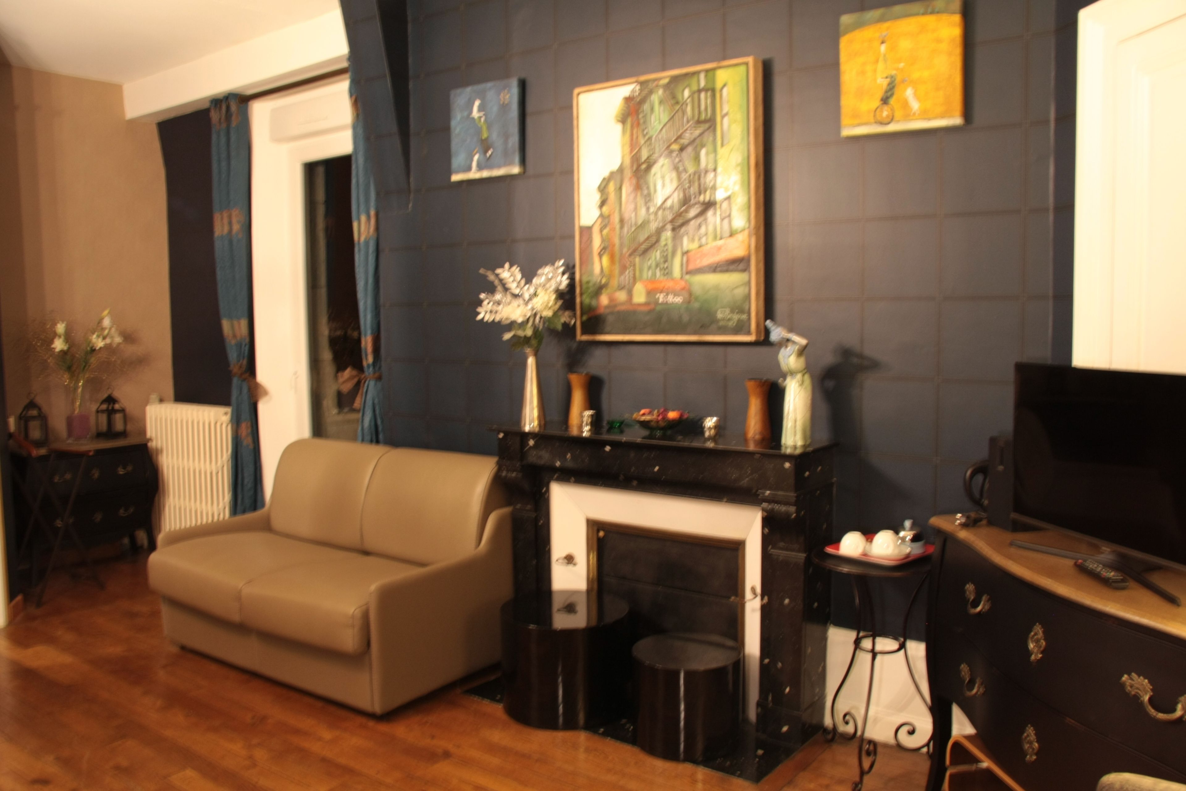 Un salon avec une cheminée, un canapé, une table basse et un téléviseur.