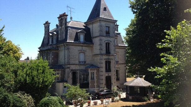 A large, historic building with multiple chimneys and a prominent tower. - Villa Primerose (Arcis-sur-Aube)