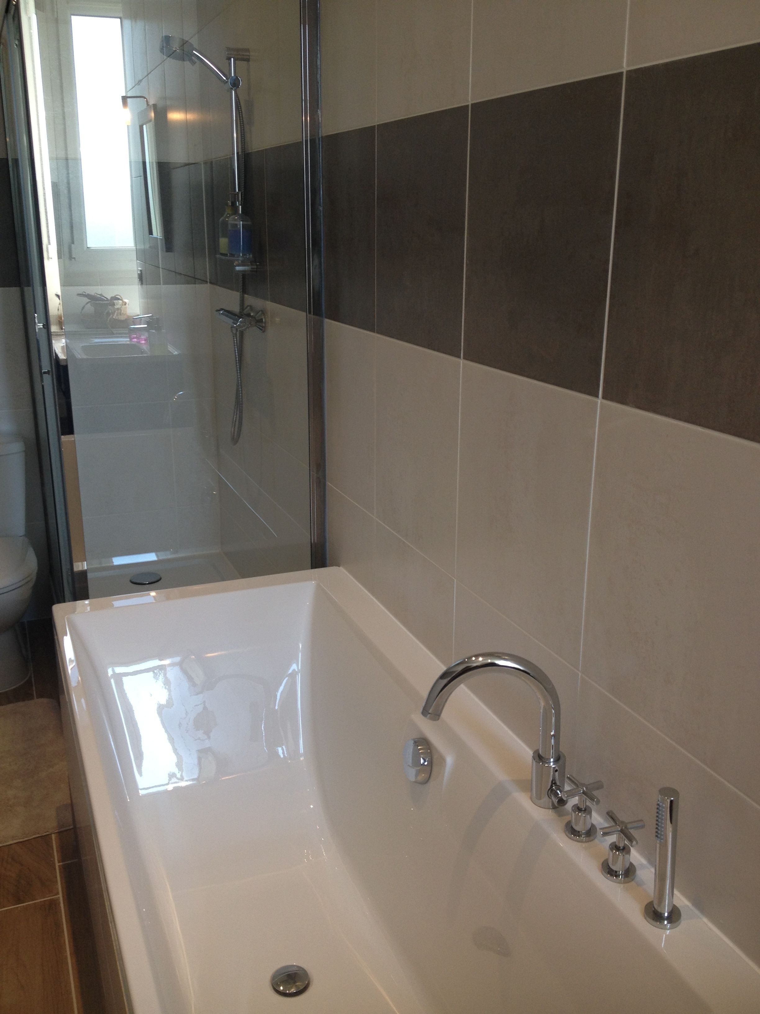 A modern bathroom with a large bathtub, a glass shower enclosure, and a toilet.