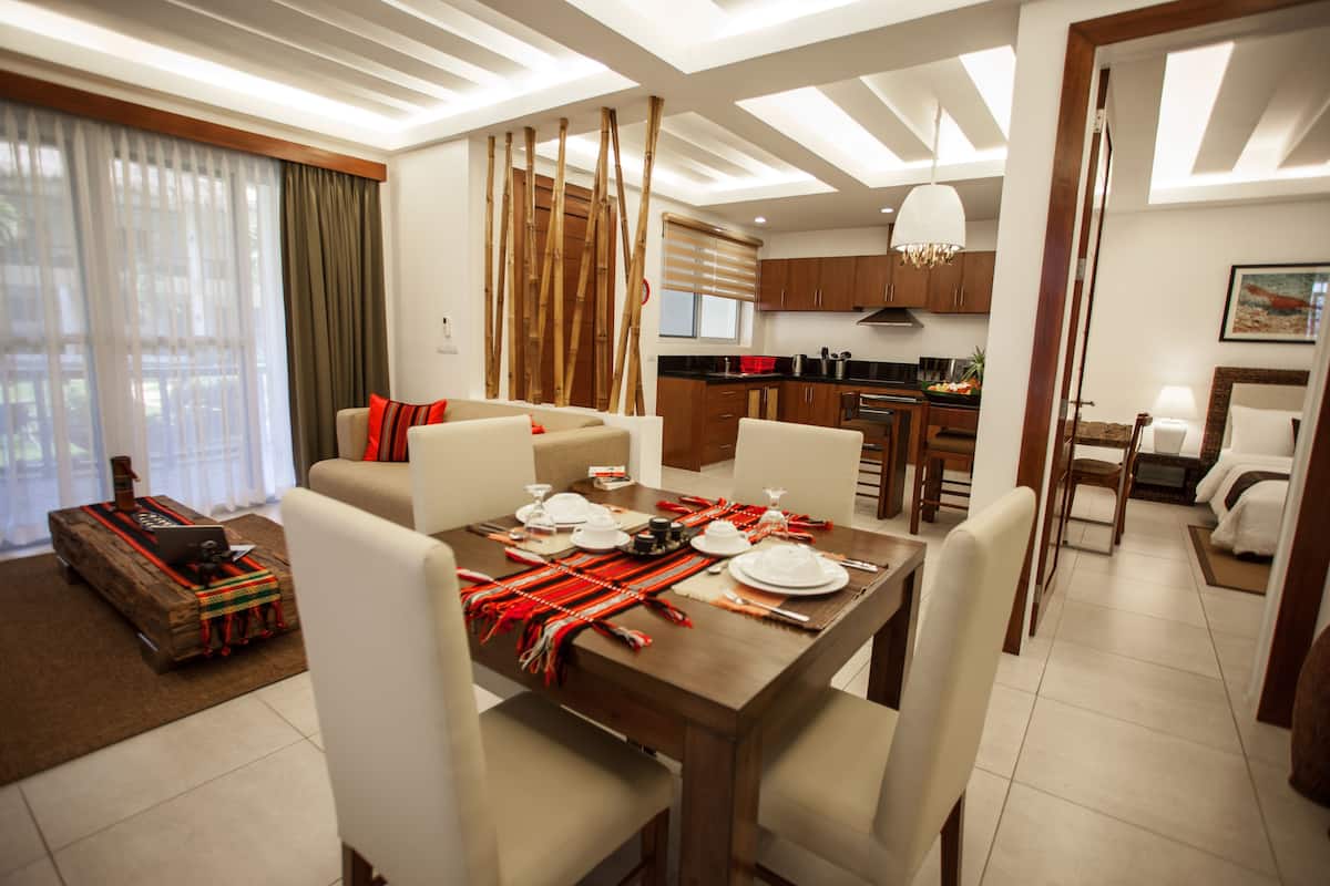 Un salon moderne comprenant un coin repas, une cuisine et une chambre avec un lit et une table de chevet.