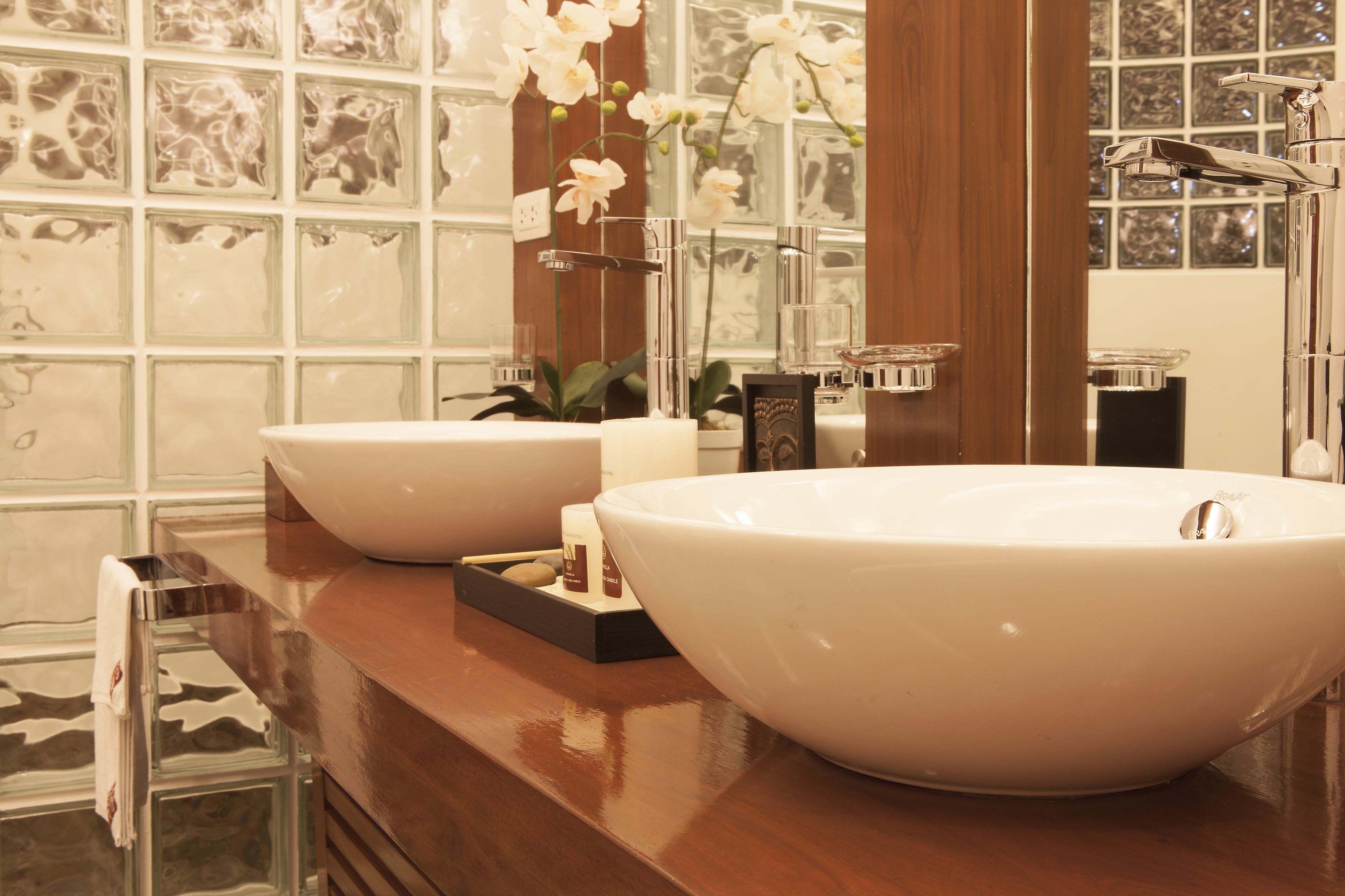 A bathroom with two large white sinks, a wooden vanity, and a mirror.