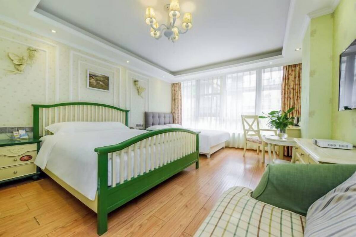 Hotellihuone, jossa on sänky, työpöytä, tuoli ja ikkuna.