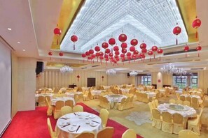 A banquet hall with round tables and chairs, a red carpet, and a decorative ceiling. - Huacheng International Hotel (Lechang)
