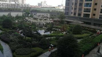 A landscaped courtyard with a pond, rock formations, and a gazebo.