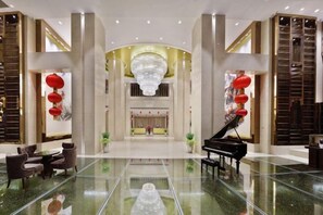 A spacious lobby with a grand piano, seating area, and a large chandelier. - Huacheng International Hotel (Lechang)