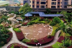 A landscaped courtyard with a central seating area, surrounded by pathways and greenery. - Huacheng International Hotel (Lechang)