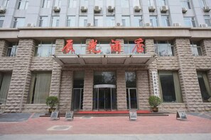 Un bâtiment à la façade en pierre et doté d’une marquise rouge ornée de caractères chinois.
