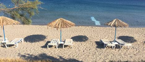 Aan het strand, ligstoelen aan het strand, parasols, strandlakens