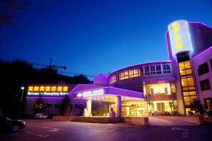 A hotel with a modern design, featuring a prominent entrance and a well-lit facade. - Shuangyang Hotel (Huairou)