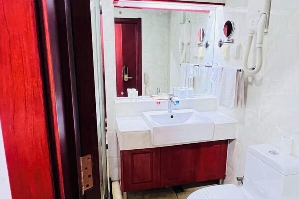 A bathroom with a white sink, mirror, and toilet. - Shuangyang Hotel (Huairou)