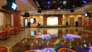 A spacious lobby with a reflective floor, multiple seating areas, and a stage. - Shuangyang Hotel (Huairou)