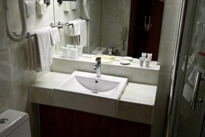 A bathroom with a sink, mirror, towel rack, and toiletries. - Shuangyang Hotel (Huairou)