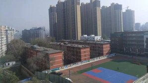 Un complejo de viviendas de altura con varios edificios de apartamentos, un campo deportivo e infraestructura circundante.