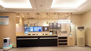 Un área de recepción con mostrador, pantallas digitales de menú y una máquina de café.
