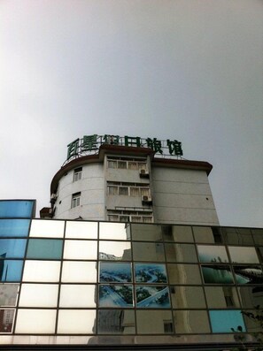 A building with a curved facade and a sign at the top. - Shanghai Baixing Hotel (Shanghai)