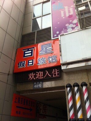 A hotel sign with Chinese characters, a welcome message, and a phone number. - Shanghai Baixing Hotel (Shanghai)