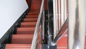 A staircase with red carpeted steps and a metal handrail. - Shanghai Baixing Hotel (Shanghai)