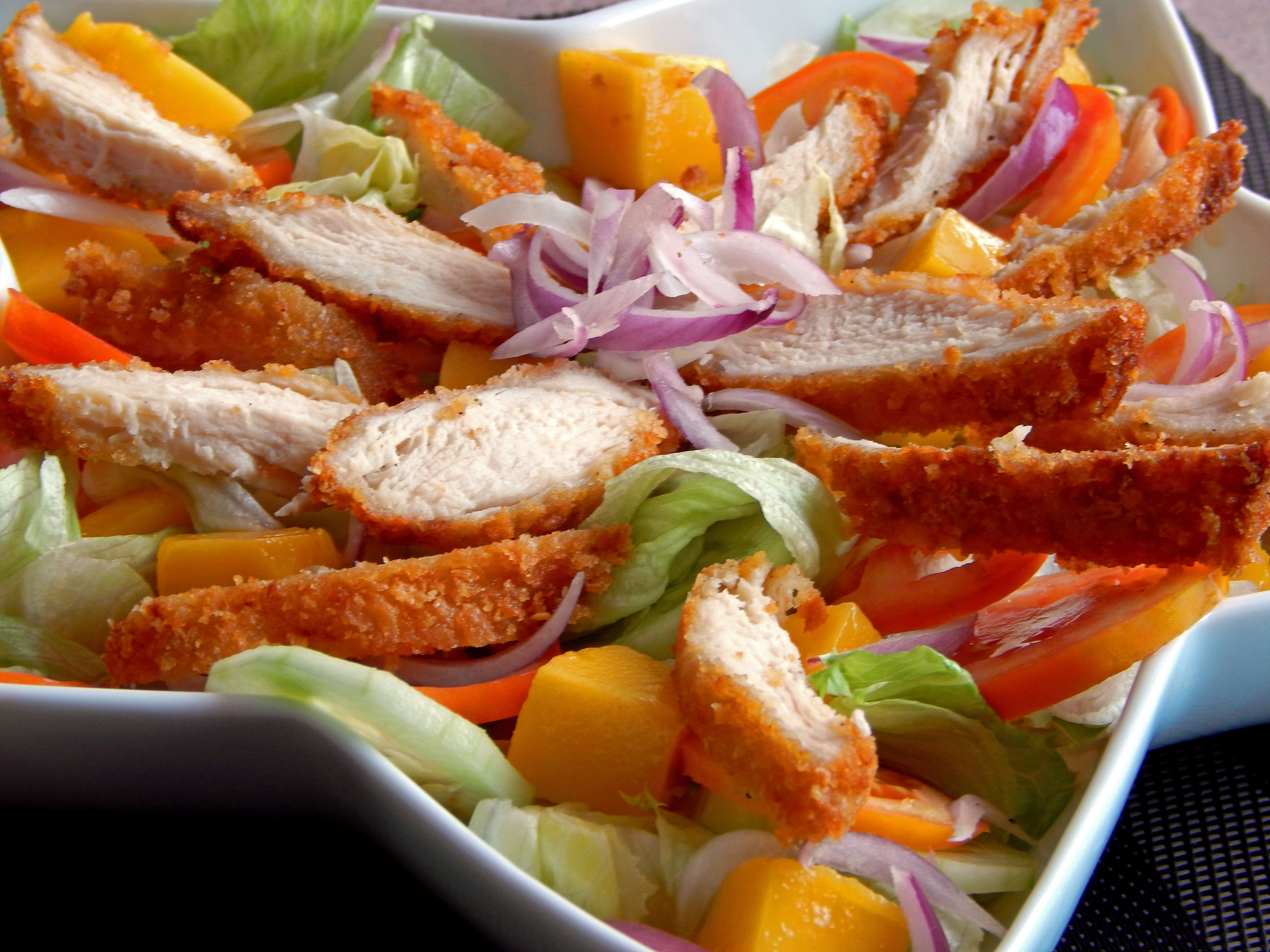 Ensalada con pollo, lechuga, zanahorias y cebollas rojas.