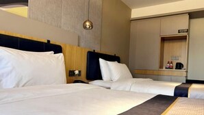 A hotel room with two beds, a wooden headboard, a bedside table with a lamp, and a mirror. - Home Inn Business Hotel (Zhengzhou 460 Hospital Bishagang Metro Station Branch) (ZHENGZHOU)