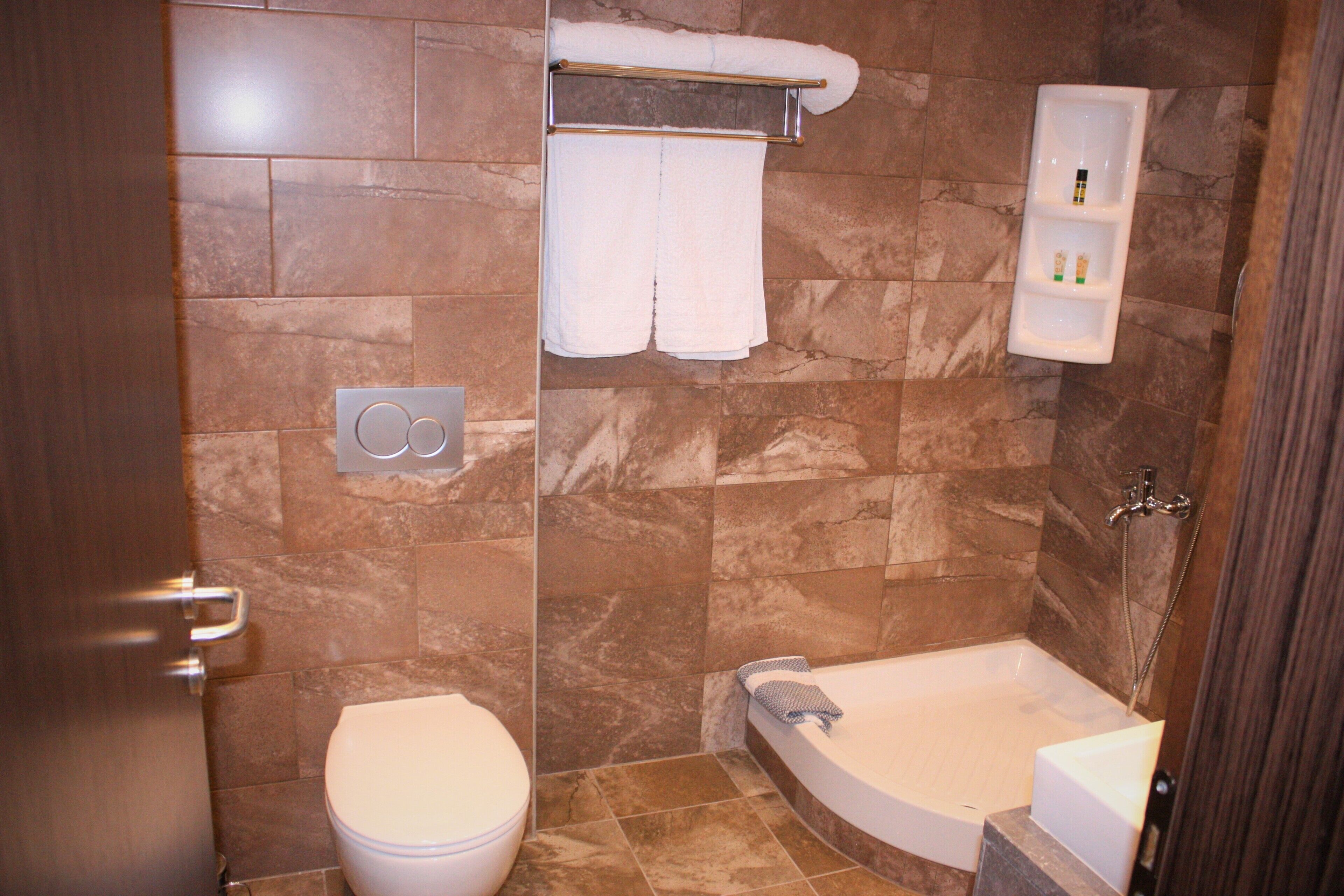 A bathroom with a toilet, a bathtub, and a towel rack.
