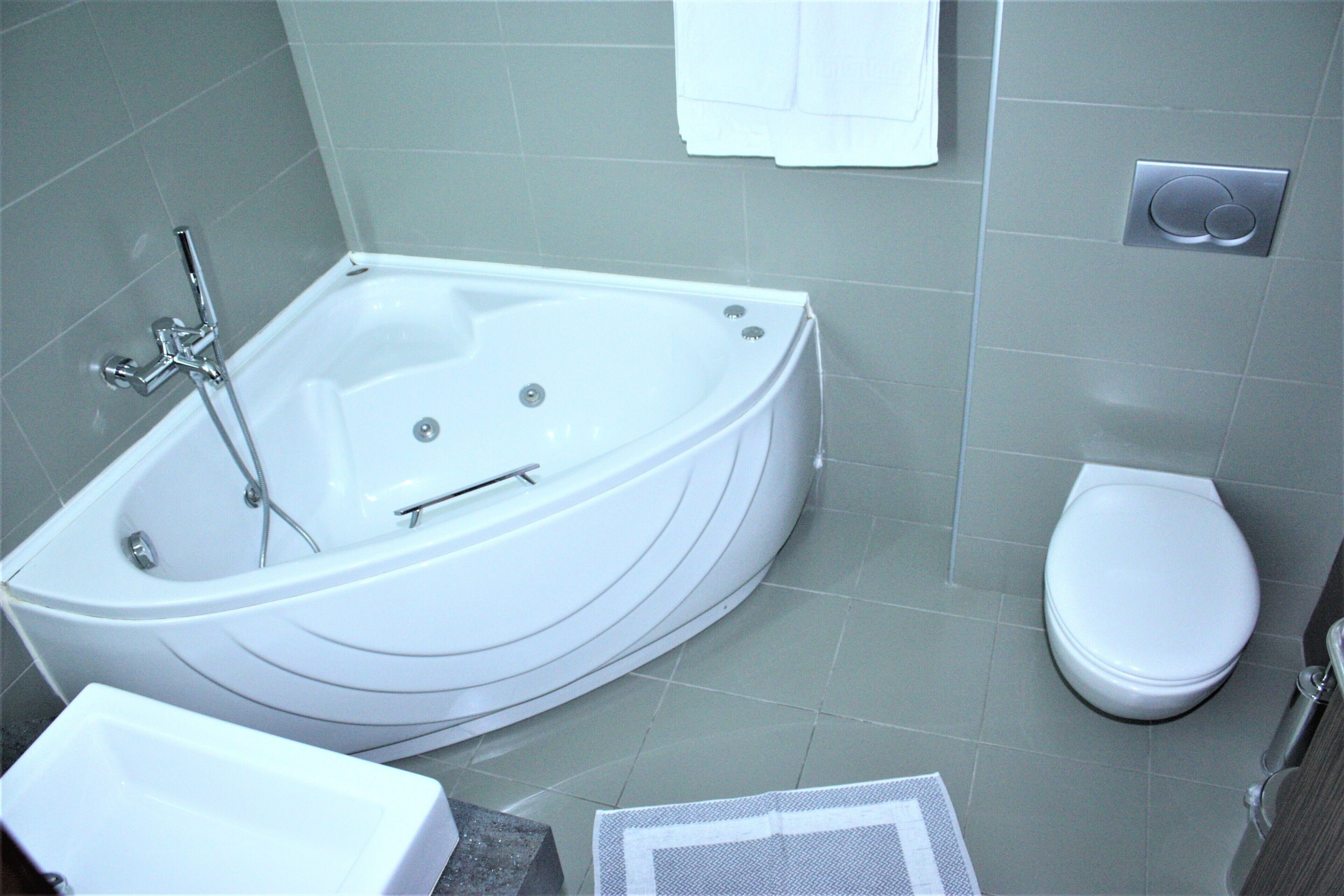 Un baño moderno con una bañera independiente, inodoro y lavabo.