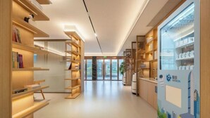 A modern library with wooden bookshelves and a large display window. - Winchi Joyu Hostel (Wenzhou)