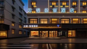 A hotel with a modern facade, featuring illuminated signage and a clean, contemporary design. - Winchi Joyu Hostel (Wenzhou)