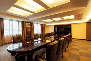 A conference room with a long table and chairs, a television, and a carpeted floor. - Huadong Hotel (Qitaihe (Xinjiang))