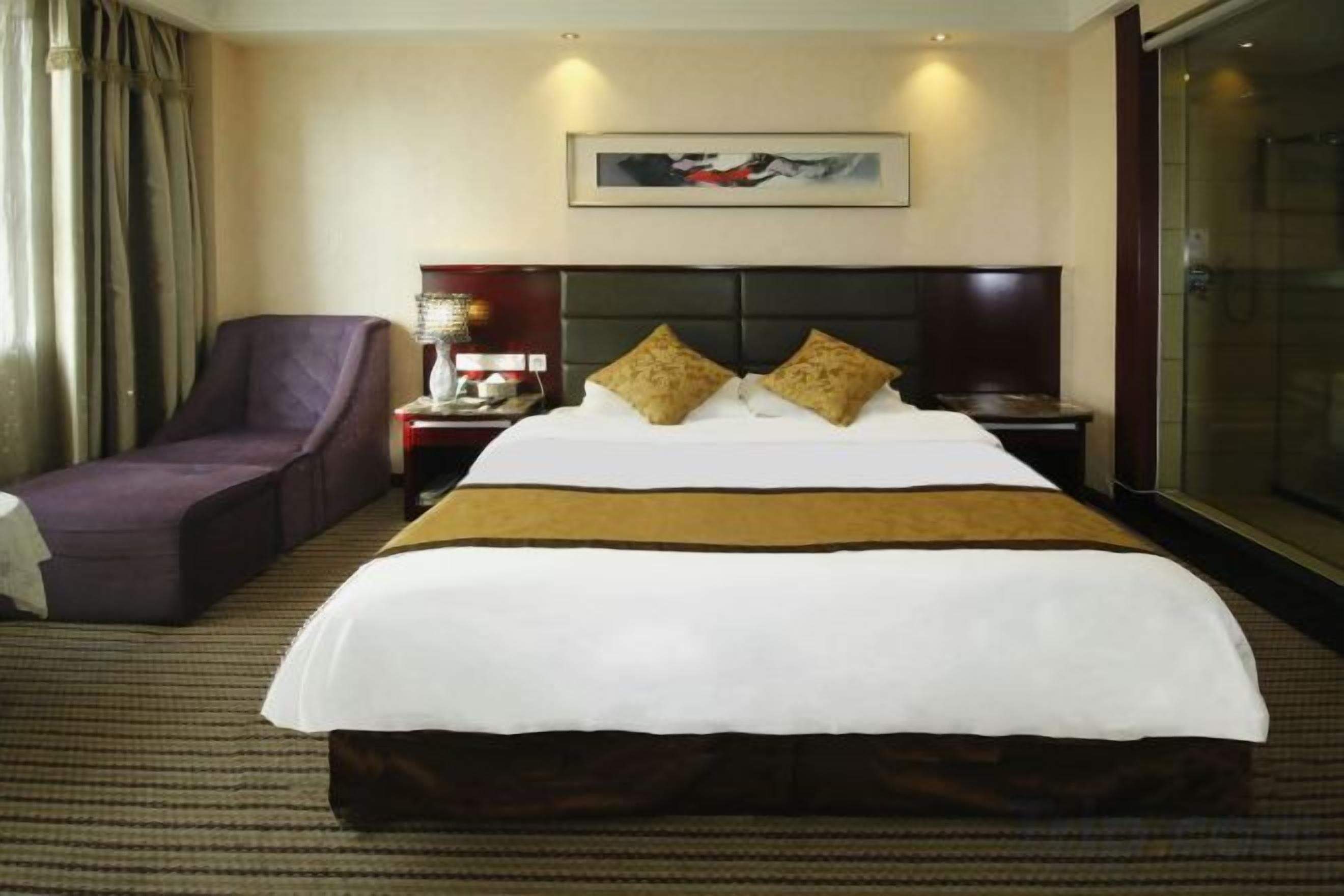 Une chambre d’hôtel avec un grand lit, une chaise, une table de chevet et une fenêtre.